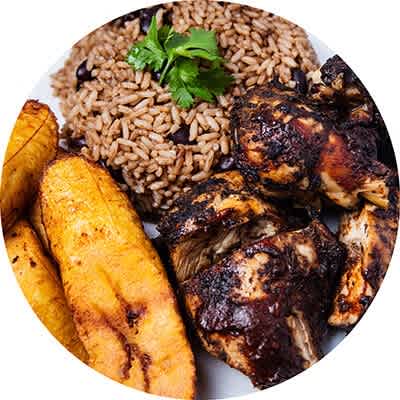 A plate of food with rice, chicken, and plantains.