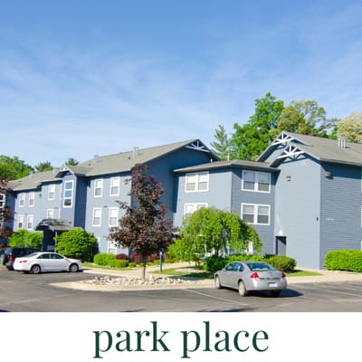 A park place with a building and cars.