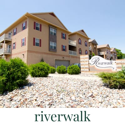 A building with a sign that says Riverwalk in front of it.