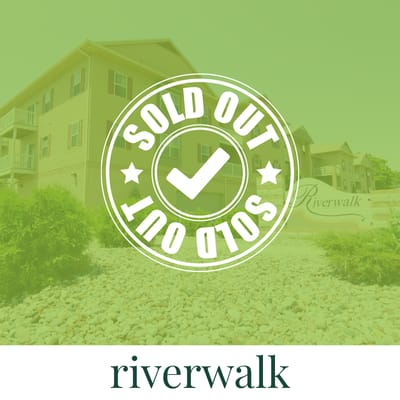A building with a sign that says Riverwalk in front of it.