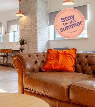 A brown leather couch with an orange pillow and a sign that says "Save money".