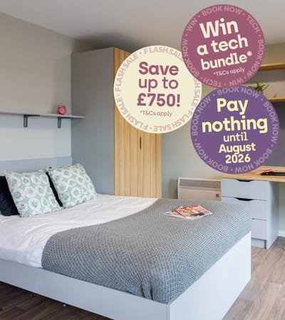 A bedroom with a bed, a desk, and a sign offering a discount on a Warwick University bus pass.