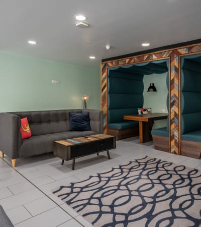 A bedroom with a bed, nightstand, and a heart-shaped graphic with a house and hearts.