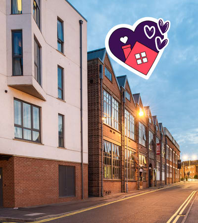 A street view of a residential area with a building on the left and a building on the right.