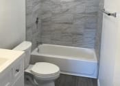 Thumbnail 6 of 11 - a bathroom with a toilet and a tub and a sink