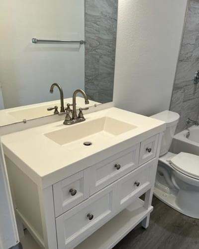 a bathroom with a white sink and a toilet