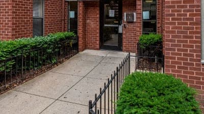 the front door of a brick building with a sidewalk