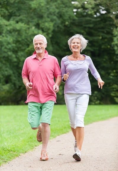 a man and a woman are jogging on a path