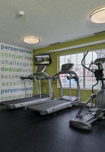 a gym with some exercise machines and a window