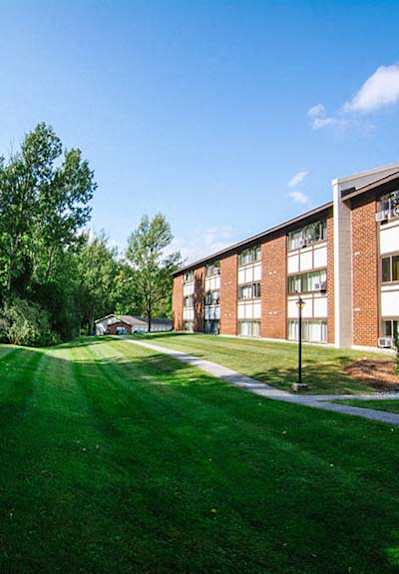 a large grassy area with a brick building in the background