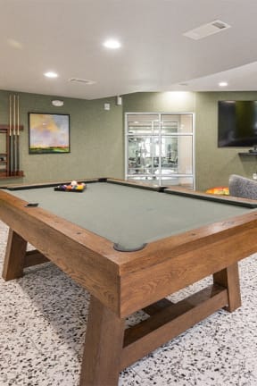 a pool table in a living room with a tv