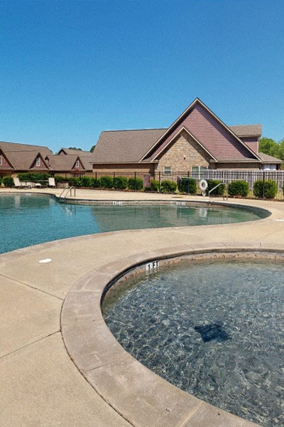a swimming pool with a house in the background