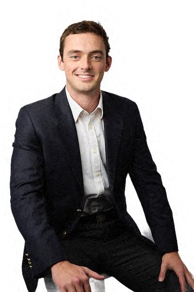 a man in a suit and tie sitting on a chair