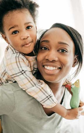 a woman holding a little girl in her arms