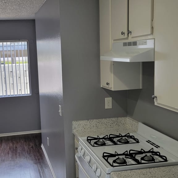an empty kitchen with a stove and a window