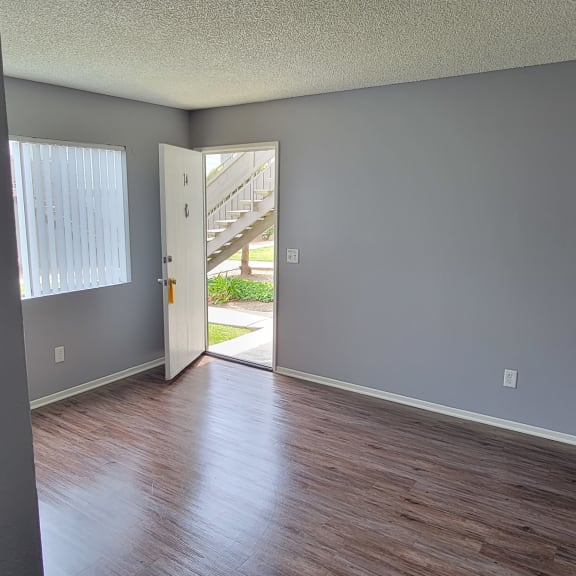 a bedroom with gray walls and hardwood floors