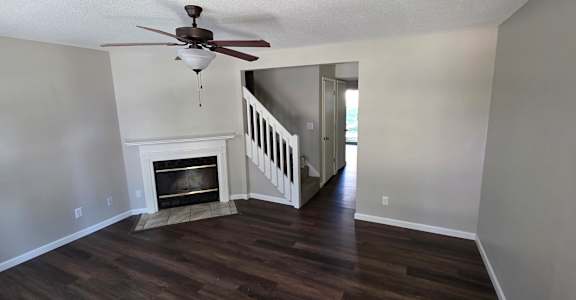 A room with a fireplace and a ceiling fan.