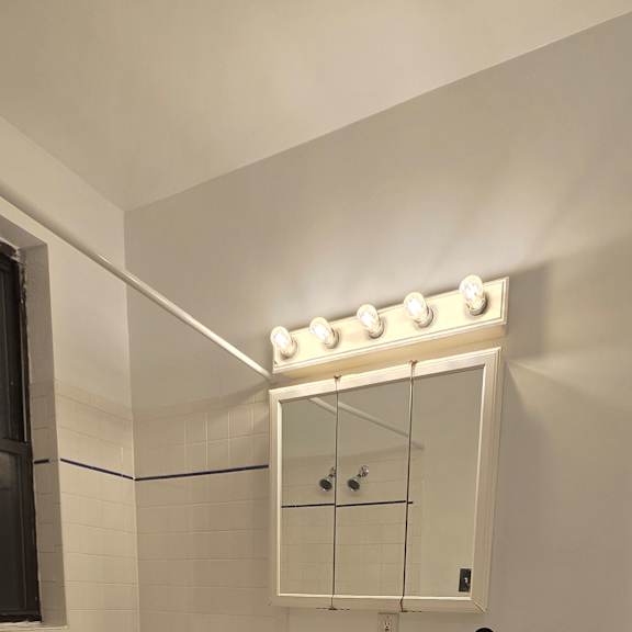 A bathroom with a toilet, sink, and mirror.