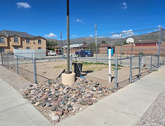 A fenced area with a gravel bed in the middle.