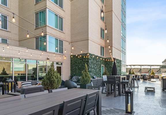 a restaurant patio with tables and chairs and a building in the background at The Zenith, Baltimore, Maryland