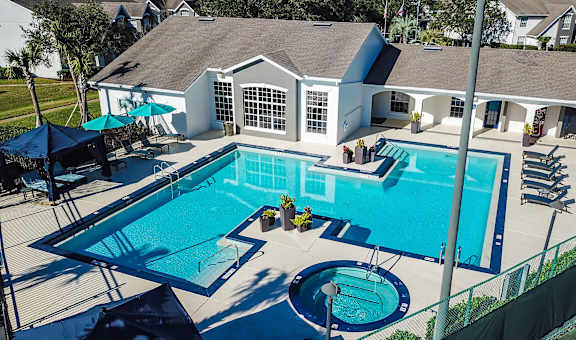 A large swimming pool with a slide and a hot tub.