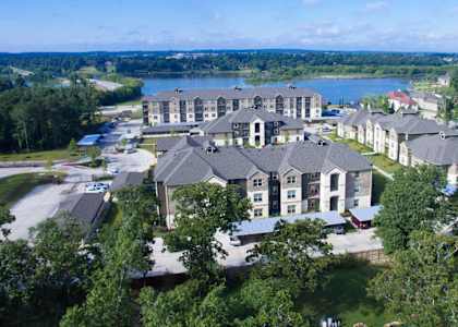 A large building complex with a lake in the background.