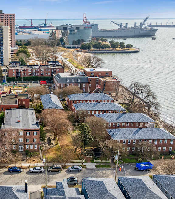 A view of a city with a large body of water and a bridge in the background. at Shipyard Shores Apartments, Newport News, 23607