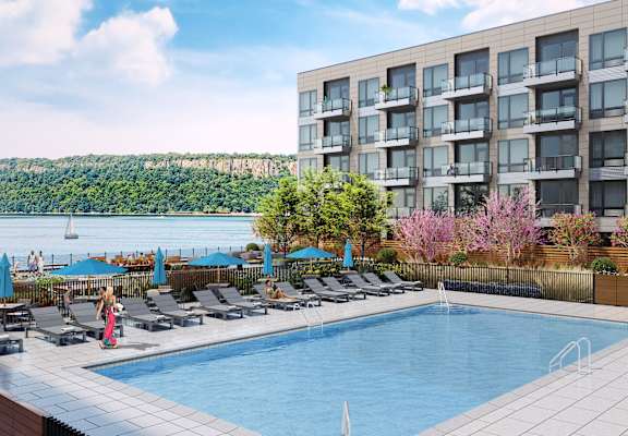 a swimming pool at a hotel with a lake in the background