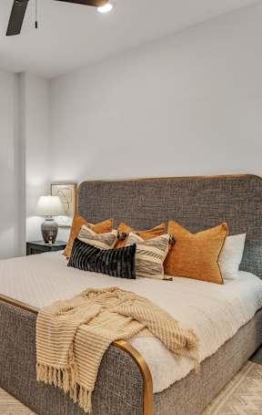 A bedroom with a large bed and a ceiling fan.