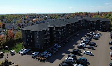 A parking lot with cars and a building in the background.
