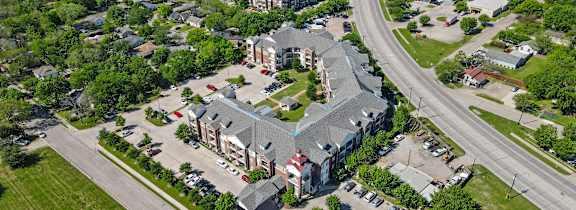Apartment building with a car parked in front.