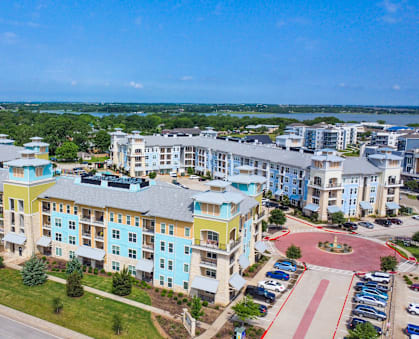 an aerial view of an apartment complex with a lake in the background