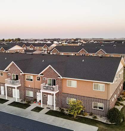 A row of houses with a grassy field in the foreground.