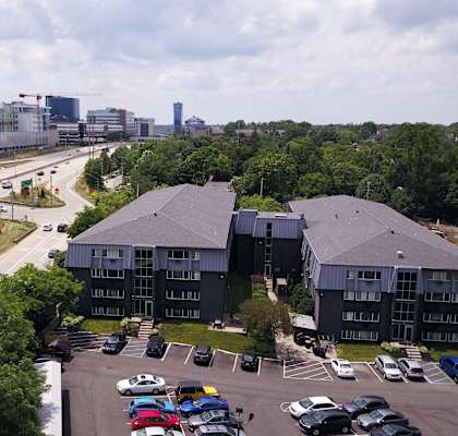 a building with a parking lot and a city in the background