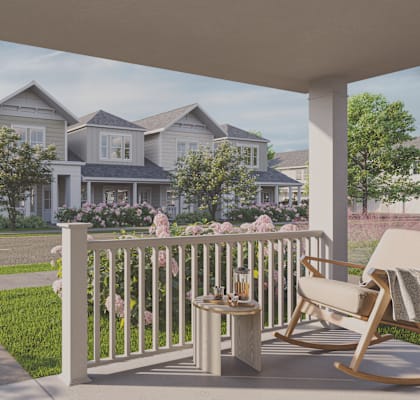 A white porch with a chair and table on it.
