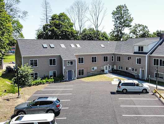 a large apartment complex with cars parked in front of it