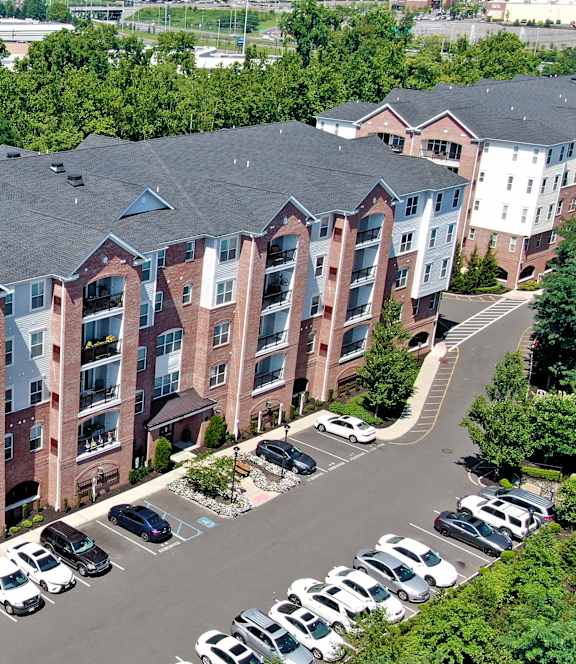 A large apartment complex with a parking lot in front.