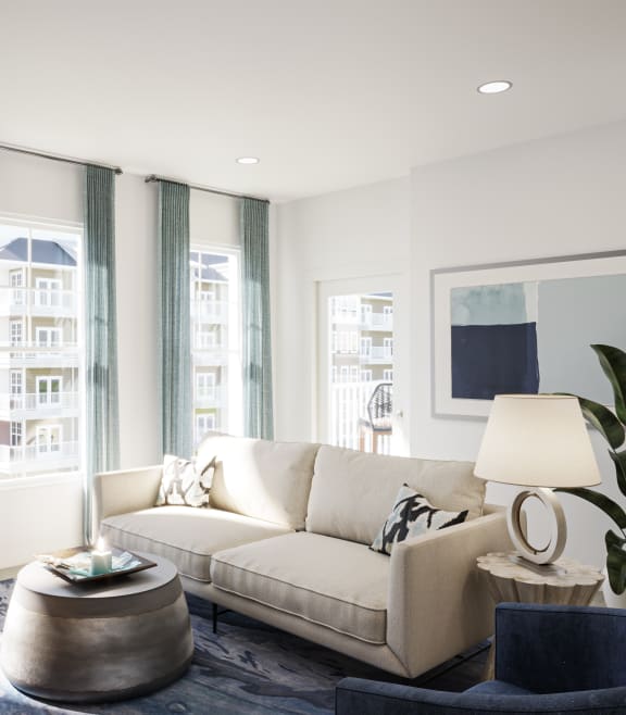 a living room with a white couch and large windows at The Port at East Beach Apartments and Marina, Virginia