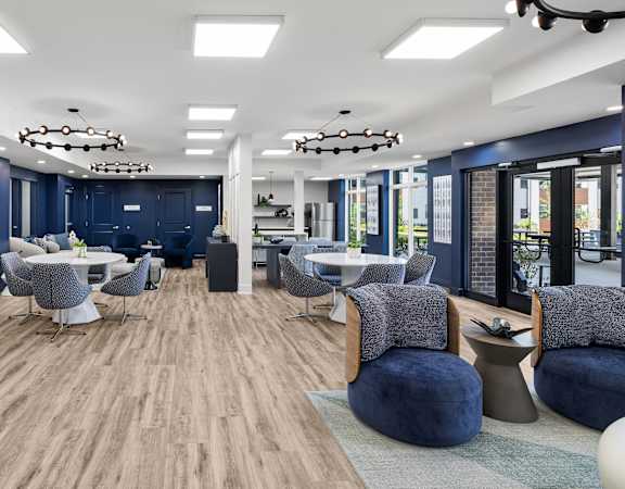 A modern lounge area with blue chairs and a wooden floor.