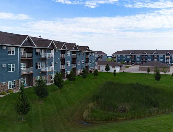 Apartment complex with green grassy area in front.