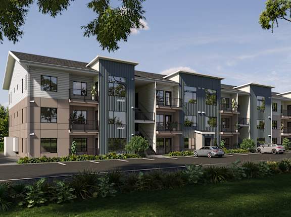 A modern apartment complex with multiple buildings and cars parked in front.