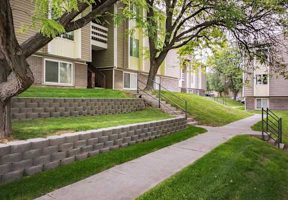 a block retaining wall on the side of a sidewalk