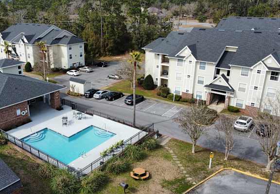 an aerial view of a swimming pool in front of some houses