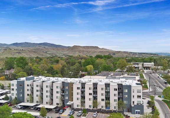 A large apartment complex with a parking lot in front.