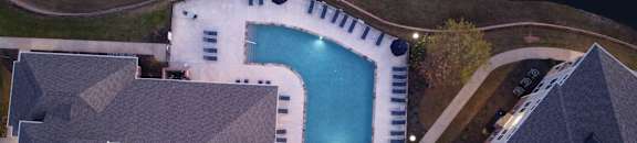 arial view of a swimming pool in a backyard at night at Cumberland Place Apartment Homes, Tyler, Texas
