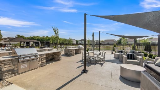 an outdoor patio with a grill and tables and chairs at Slate at Fishers District, Fishers, IN, Indiana, 46037