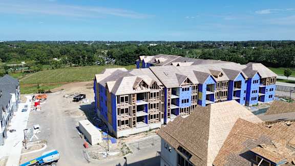 A large building under construction with a blue and white exterior.