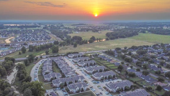 an aerial view of a neighborhood with a sunset in the sky at Landing at Willow Bayou in Bossier City, LA 71111