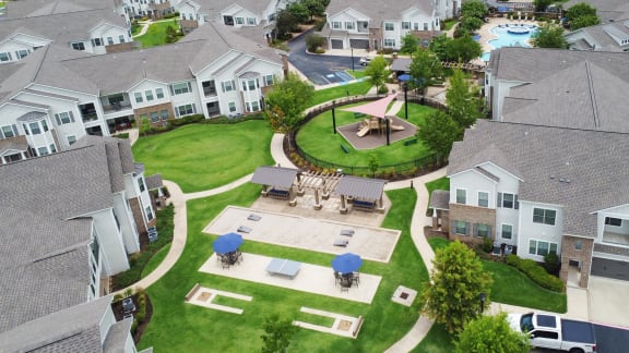 a patio with umbrellas and a brick walkway  at Kingston Crossing Apartment Homes, Bossier City, Louisiana