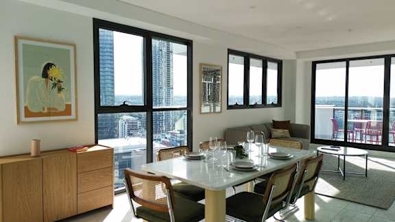 A dining room with a table set for two and a view of the city.